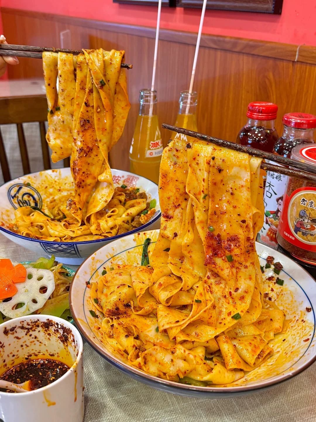 Steaming bowl of biangbiang noodles with dipping sauce